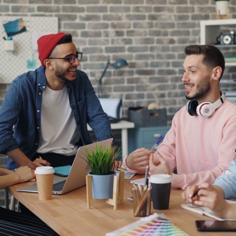 a group of people sitting around a wooden table